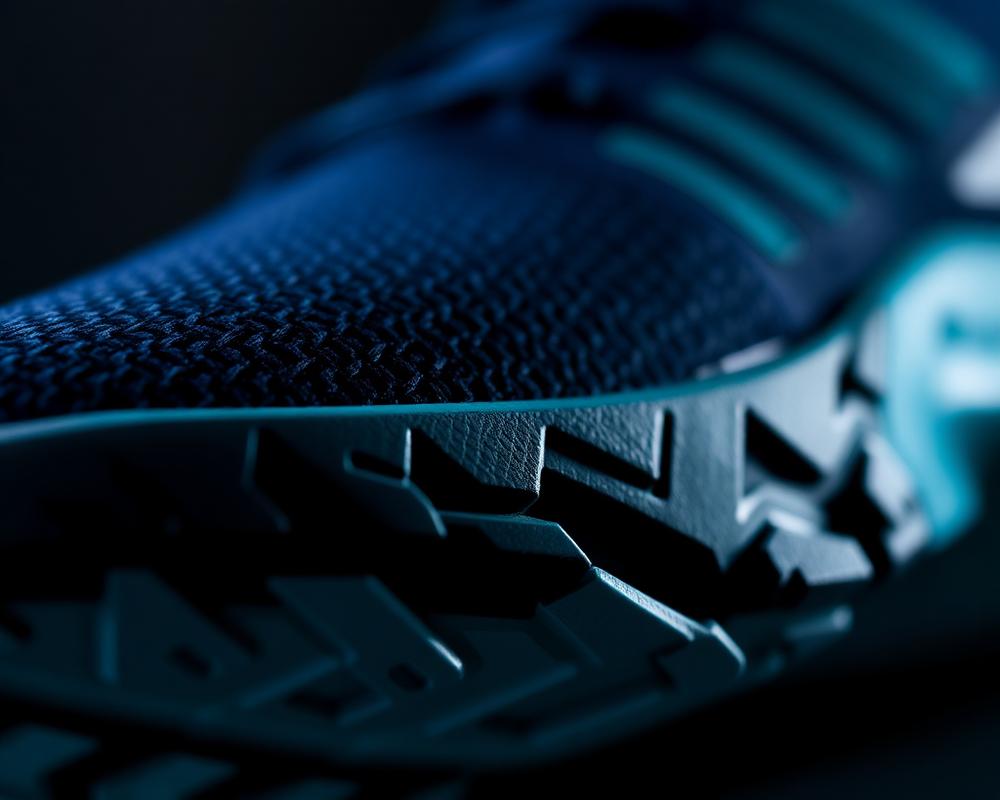 Macro detail of a knit sneaker upper meeting a sculpted rubber outsole